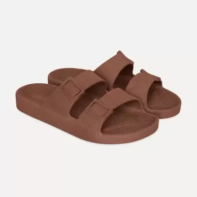 Sandálias castanhas de banho com duas tiras largas e fivelas sobre fundo branco