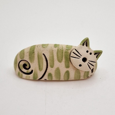Figura cerâmica de gato alongado bege e verde sobre fundo branco