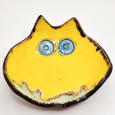 Prato decorativo amarelo em forma de cabeça de gato com olhos azuis