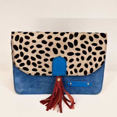 Carteira azul de camurça com aba de padrão animal preto e branco e franjas castanhas