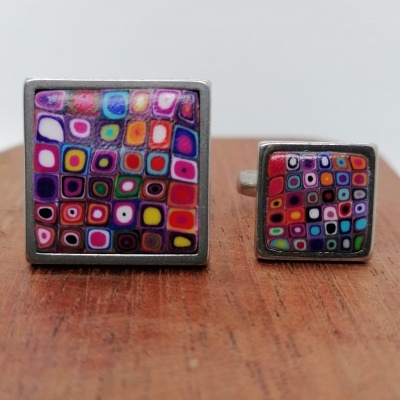 Anel e anel de falange quadrados coloridos em metal prateado sobre madeira