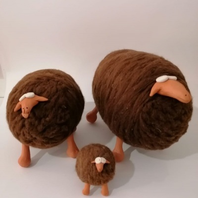 Três figuras decorativas de ovelhas castanhas com textura felpuda