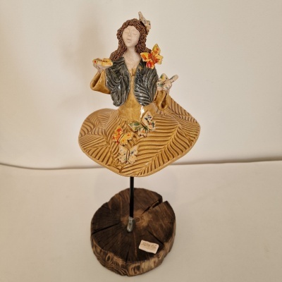 Estátua decorativa de mulher em cerâmica com flores e base de madeira
