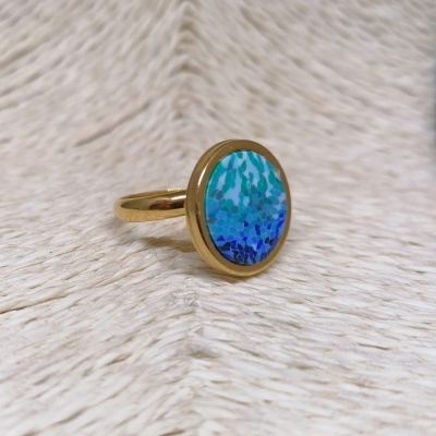 Anel dourado com pedra oval em tons de azul e verde