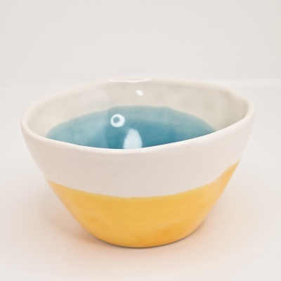 Tigela cerâmica azul, branca e amarela com acabamento irregular