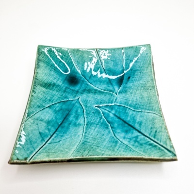 Prato quadrado de cerâmica azul turquesa com textura de folhas