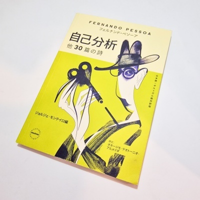 Livro com capa amarela e creme com ilustração e texto em japonês