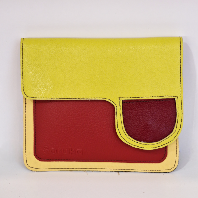 Carteira de couro amarelo, vermelho e bege com textura granulada e texto Sonuka