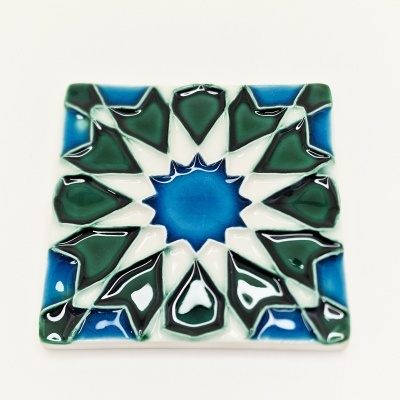 Azulejo quadrado decorativo em cerâmica com padrão geométrico azul, verde e branco