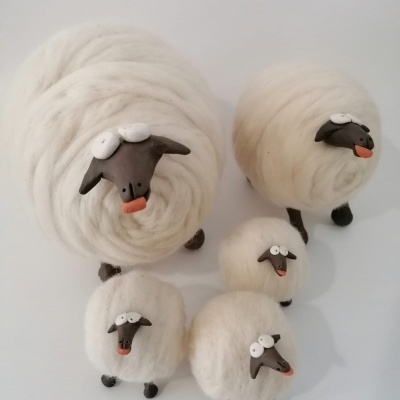 Cinco ovelhas decorativas brancas de lã com cabeça e patas pretas e detalhes cor-de-rosa