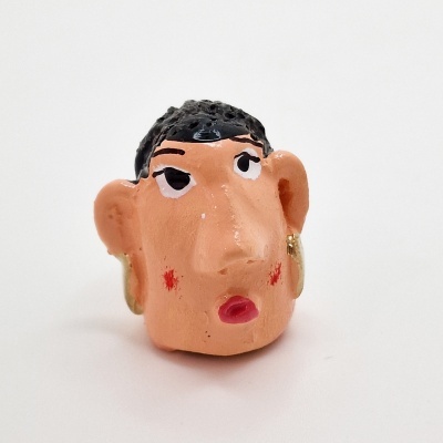 Peça decorativa cabeça humana pintada à mão com cabelo preto e brincos dourados