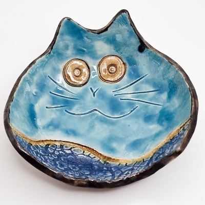 Prato cerâmico azul em forma de cabeça de gato com olhos dourados e detalhes texturizados