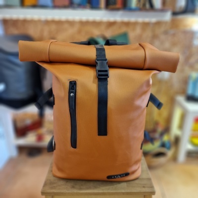 Mochila castanha clara com fecho de enrolar e bolso frontal preto