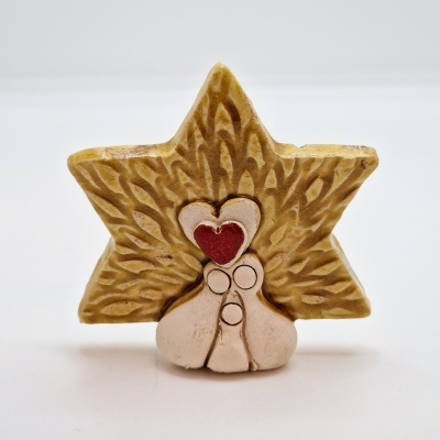 Peça decorativa em cerâmica em forma de estrela dourada com figuras e coração vermelho no centro