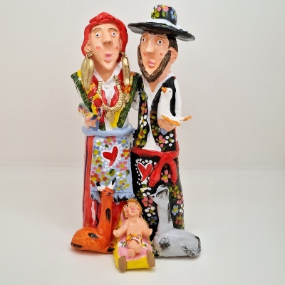 Figura artesanal colorida com casal, animais e bebé em berço