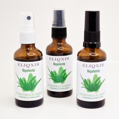 Três frascos marrons de repelente com rótulo branco e planta verde