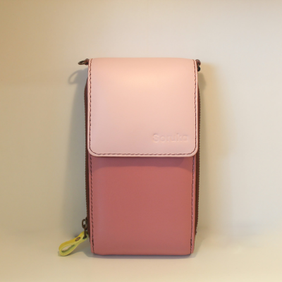 Bolsa rosa pequena de pele com alça amarela suspensa