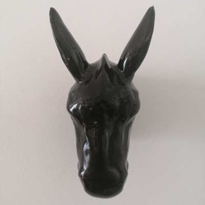 Cabeça de burro decorativa em cerâmica preta na parede