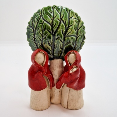 Escultura cerâmica três figuras com capas vermelhas e árvore verde