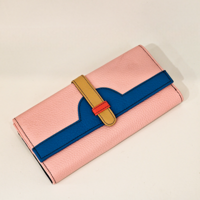 Carteira de couro rosa com detalhe azul e fecho amarelo sobre fundo branco