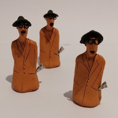 Três figuras decorativas de homens com chapéu e óculos em cerâmica ou barro