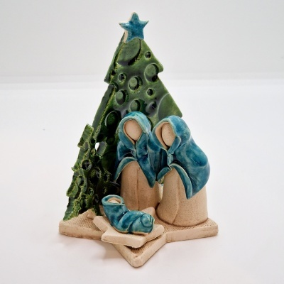 Presépio natalício em cerâmica com figuras em azul e bege e árvore verde com estrela azul