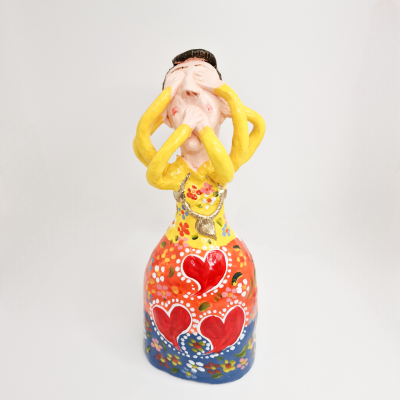 Figura decorativa colorida em cerâmica com corações vermelhos e laços amarelos.
