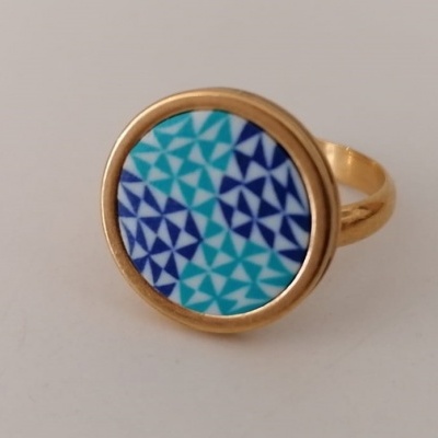 Anel dourado com padrão geométrico azul