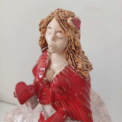 Estatueta mulher vestida de vermelho segurando coração