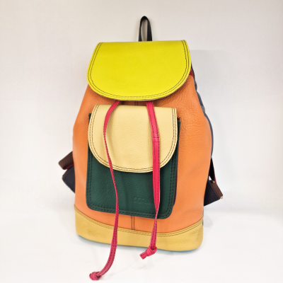 Mochila colorida de pele com várias bolsas e tiras sobre fundo branco