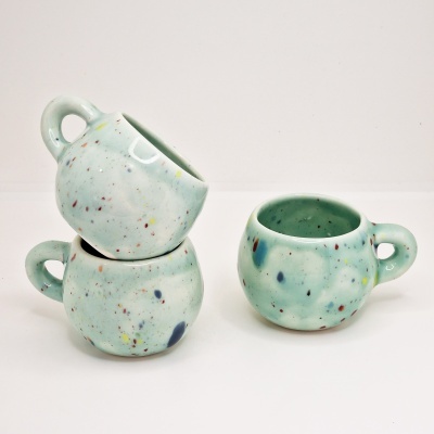 Conjunto de três chávenas de cerâmica verde claro com salpicos coloridos