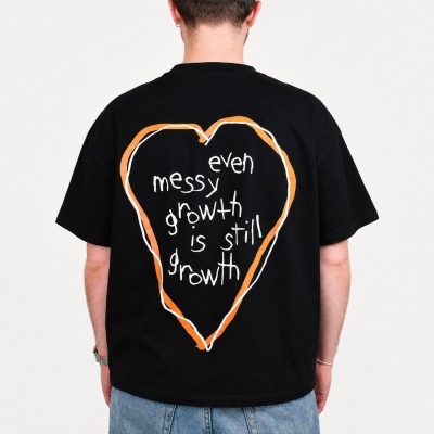 Black t-shirt with orange and white heart design and text on the back