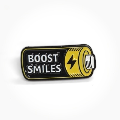 Battery-shaped enamel pin with BOOST SMILES text and lightning bolt symbol