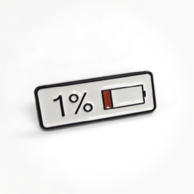 Enamel pin showing 1% with a low battery icon in black, white, and red colors