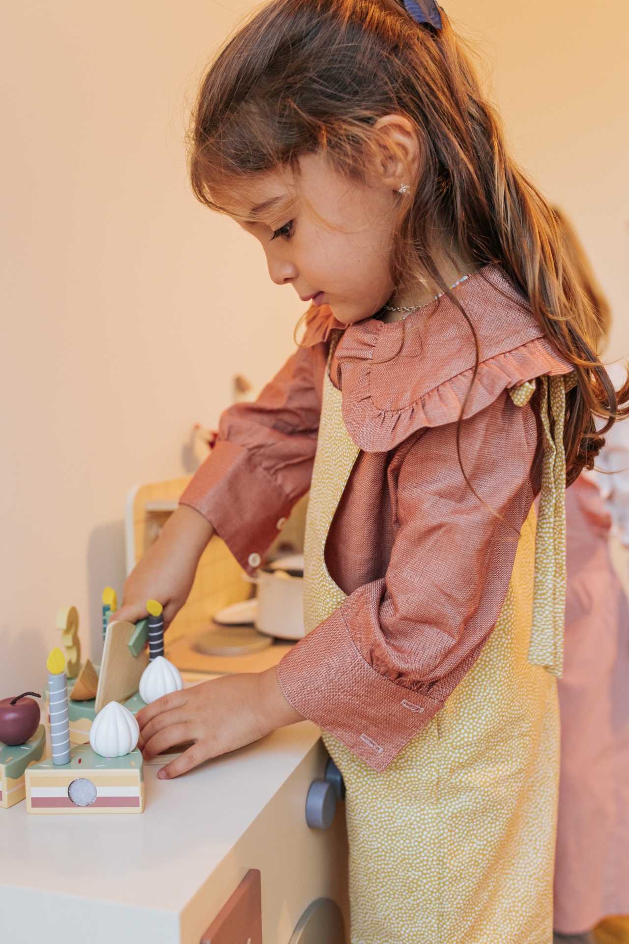 Camisa Telha Menina a brincar com brinquedos de legumes de madeira