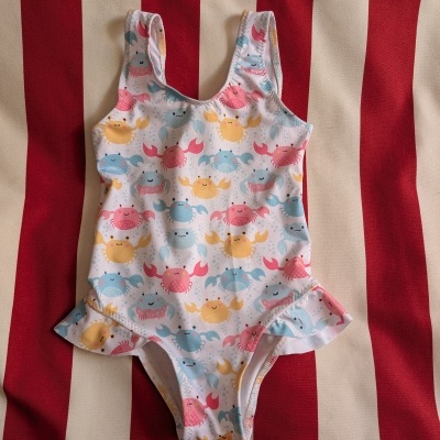 Fato de banho infantil branco com caranguejos coloridos e folho nas pernas