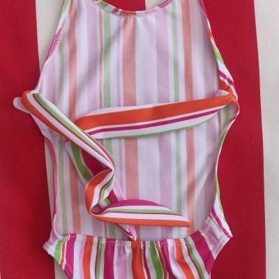 Fato de banho de criança listrado colorido com tiras largas.
