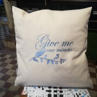 almofada branca com bordado azul e banco com padrão de teclas