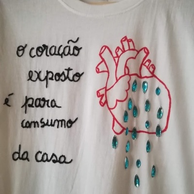 Camiseta branca com estampa de coração vermelho e texto em preto