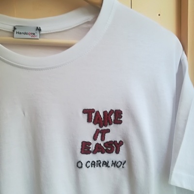 T-shirt branca com texto bordado vermelho e preto