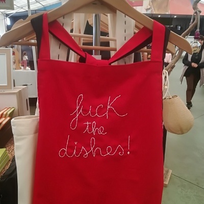 Avental vermelho com texto bordado 'fuck the dishes!'