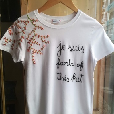 T-shirt branca com bordado floral e texto em preto