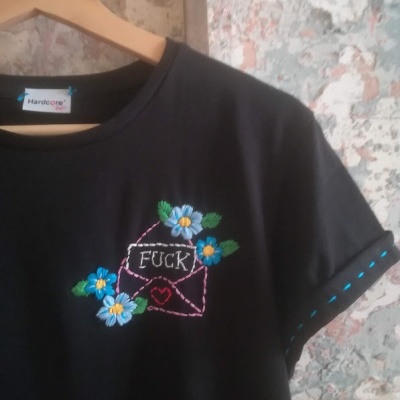 T-shirt preta com bordados florais e texto na frente
