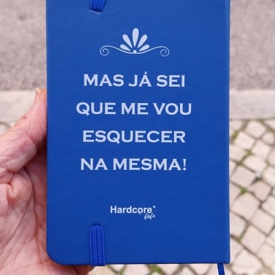 Caderno azul com texto branco e fecho elástico