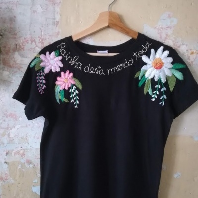 T-shirt preta com bordados florais e frase bordada no peito