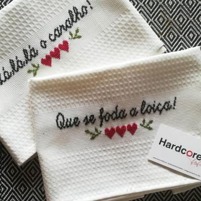 Toalhas de cozinha brancas com bordado e padrão waffle sobre tecido preto e branco