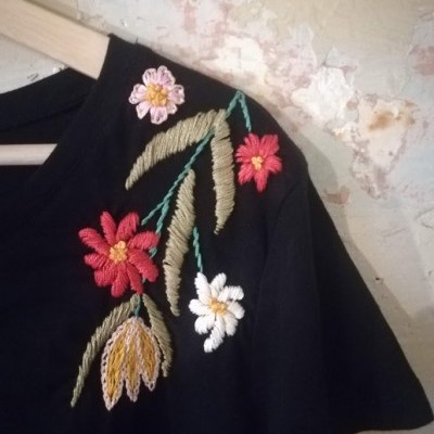 T-shirt preta com bordados florais coloridos na manga