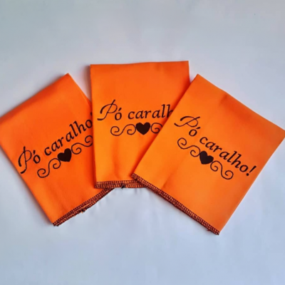 Três panos laranja com frase 
