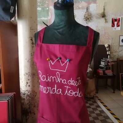 Avental bordado vermelho vinho em manequim preto com texto e coroa