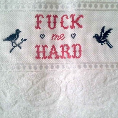 Toalha branca bordada com texto e pássaros pretos